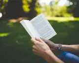 Ciało kobiety, mądrość kobiety. Kobieta czyta książkę w parku, pogrążona w lekturze.