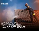 Pracownik myje dach myjką ciśnieniową, przygotowując go do malowania. Dowiedz się, czym umyć dach przed malowaniem i jak go odtłuścić.