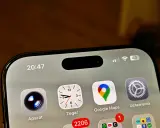 Ekran iPhone z widoczną dynamiczną wyspą, ikonami Aparat, Zegar, Google Maps i Ustawienia. Czas 20:47.