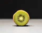 Połówka kiwi, idealna na keto, z widocznymi czarnymi pestkami i zielonym miąższem.