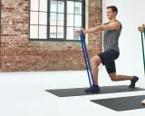 Mann und Frau machen Ausfallschritte mit Widerstandsbändern. Effektives HIIT Training für zu Hause.