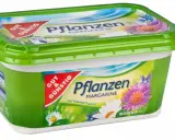 Grüne Margarine-Packung mit Blumenmotiv. Sie besteht aus Pflanzenöl und enthält Vitamine D und E.