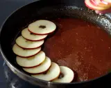 Äppelringar läggs i en panna med karamelliserad sås, förberedelse för en klassisk tarte tatin.