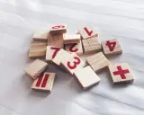 Drewniane klocki z cyframi 1, 2, 3, 4, 6, 7, 11 i znakiem plus. Jak wyliczyć numerologię?