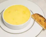 Crème onctueuse à la noix de coco, servie dans un bol blanc avec une tranche de pain grillé.