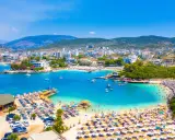 Albania plaża, która wyglądem przypomina Bora Bora, z turkusową wodą, białym piaskiem i mnóstwem turystów.