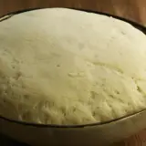 Wyrośnięte ciasto na pizzę w misce, gotowe do dalszej obróbki. Tak wygląda idealne ciasto, gdy wiesz, jak zrobić ciasto na pizzę.