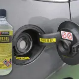 Butelka dodatku do oleju silnikowego diesel Venol Diesel Entfroster obok otwartego wlewu paliwa.