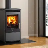 Poêle à bois Cadel en feu, avec une vue sur un paysage enneigé. L'alarme pressostat assure un fonctionnement sûr.