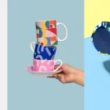 Collection d'objets aux motifs colorés et audacieux : tissu, survêtement, tasses, lunettes de soleil et sac. Une création textile vibrante.