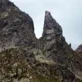 Surowe, skaliste zbocza Tatr poza szlakiem, z ostrym szczytem dominującym nad krajobrazem.