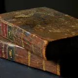 Dwa stare, zniszczone księgi. Na grzbietach widoczne etykiety z łacińskimi napisami i cyframi rzymskimi, sugerujące zawartość, np. psalm 6.