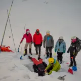Ratownicy ćwiczą akcję ratunkową po lawinie w Tatrach. Jedna osoba zasypana, inni szukają jej w śniegu.