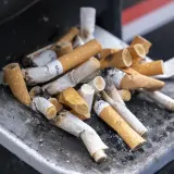 Kupa niedopałków papierosów w popielniczce. Zastanawiasz się, ile kosztują papierosy we Francji?