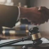 Sądowy młotek i uścisk dłoni symbolizują zakończenie sprawy. Libor co to? To może być początek nowego rozdziału.