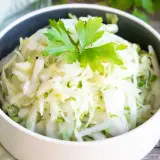Frischer Krautsalat, perfekt zum krautsalat selber machen. Mit Petersilie garniert, serviert in einer Schüssel.
