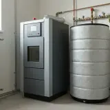 Nowoczesny piec na pellet z zasobnikiem i buforem do pieca na pellet, podłączony do instalacji grzewczej.
