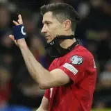 Robert Lewandowski, kapitan kadry, w czerwonej koszulce z opaską "C" na ręce i maską RL9 na twarzy.