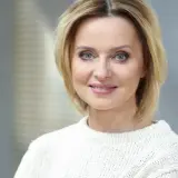 Jolanta Pieńkowska w białym swetrze, z uśmiechem na twarzy. Spekulacje o jej operacje plastyczne krążą od lat.