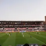 Mecz na madryckim stadionie. Piłkarze biegają po zielonej murawie, a trybuny wypełniają kibice.