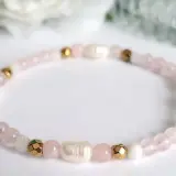 Delikatna bransoletka z koralików kwarc różowy, pereł i złotych elementów. Symbol miłości i harmonii.