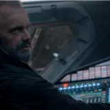 Un homme barbu, casque sur les oreilles, aux commandes d'un vaisseau spatial. L'avenir de l'humanité est en jeu dans For All Mankind saison 5.
