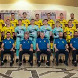 Drużyna piłkarska Wieczysta Kraków w komplecie. Zawodnicy i sztab szkoleniowy pozują do wspólnego zdjęcia w strojach klubowych.