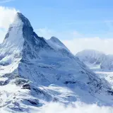 Majestatyczny szczyt Matterhorn, korona Europy, w otoczeniu innych ośnieżonych gór.