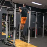 Mężczyzna wykonuje podciąganie na drążku w siłowni. To element skutecznego powerlifting plan treningowy.