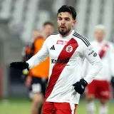 Piłkarz Stali Mielec w białej koszulce z czerwonym pasem, gotowy do gry przeciwko ŁKS Łódź.