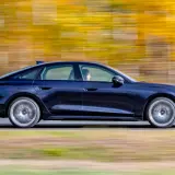 Ciemnoniebieskie Audi A4 B10 w ruchu, z rozmytym jesiennym tłem.