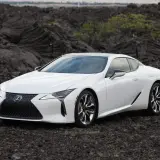 Biały Lexus LC 500 na tle wulkanicznych skał.
