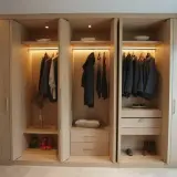 Drewniana szafa na wymiar z oświetleniem LED, wieszakami z ubraniami i szufladami. Idealna inspiracja, jak zrobić szafę na wymiar.