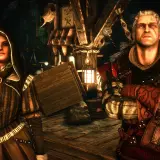 Geralt i tajemnicza kobieta w kapturze stoją w mrocznym wnętrzu. W tle widać drewniane konstrukcje i latarnie.