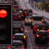 Czerwone światło na fotoradarze na światłach zatrzymuje sznur samochodów w zimowy dzień.