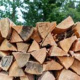 Stapel von gespaltenem Holz, bereit für den Winter. Der hohe Brennwert von Ulmenholz macht es zu einer beliebten Wahl für Kaminholz.