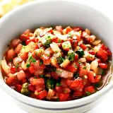 En skål med färsk salsa, perfekt för ditt salsa recept. Tomater, lök och örter blandas till en läcker röra.