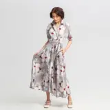 Elegancka stylizacja na wieczór: zwiewna sukienka maxi w kwiaty, z wiązaniem w talii i dekoltem koszulowym.