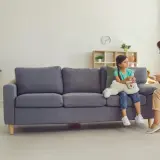 Psycholog dziecięcy rozmawia z dziewczynką siedzącą na kanapie z pluszowym misiem.