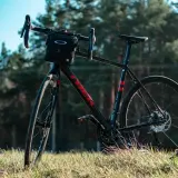 Czarny rower gravelowy z sakiewką na kierownicy, gotowy na wyprawę wzdłuż rzeki Loary.