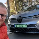 Mężczyzna w czerwonej kurtce robi selfie z nowym Renault Megane E-Tech.