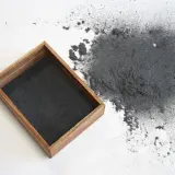 Un tas de flocage qui s'effrite s'est répandu à côté d'un plateau en bois rempli de la même matière.