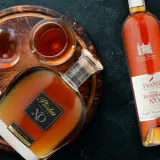 Butelka i kieliszki z bursztynowym brandy. To jest co to jest brandy - szlachetny trunek.