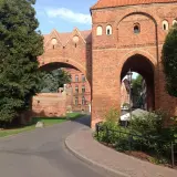Brama w Sokołowie Podlaskim, ceglana architektura i zielone drzewa. Odkryj atrakcje tego miejsca!