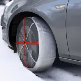 Neumático de coche con cadenas de nieve puestas, ideal para saber donde se colocan las cadenas de nieve en condiciones de hielo.