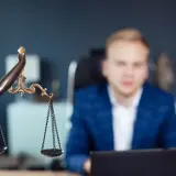 Waga sprawiedliwości i mężczyzna w garniturze. Czy czysty BIK to gwarancja, czy odmowa kredytu?