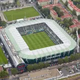 Widok z lotu ptaka na Allianz Stadion, gdzie zielona murawa i trybuny wypełnione kibicami czekają na mecz.