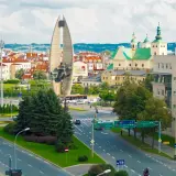 Widok na pomnik, kościół i ruchliwe skrzyżowanie w Lublinie.