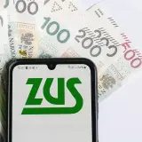 Telefon z logo ZUS na tle polskich banknotów. Czy to zapowiedź świadczenia wspierającego 2026?