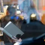 Kobieta czyta książkę w księgarni. Autorzy mogą poznać jakie dane o sprzedaży książek są dostępne dla nich dzięki Nielsen Bookscan.